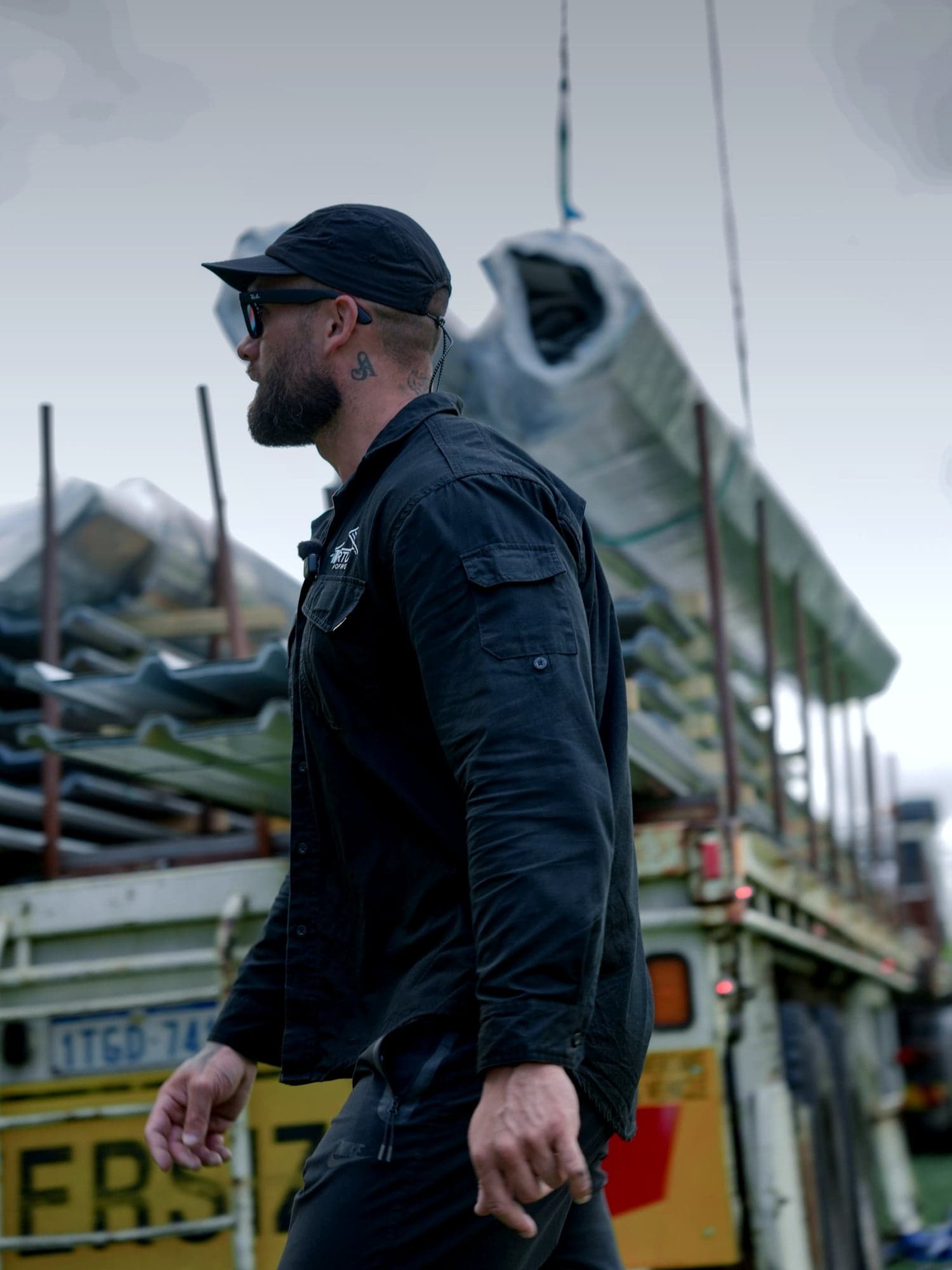 Jake Ruwhiu, director of Virtue Roofing, beside a truck loaded with roofing steel