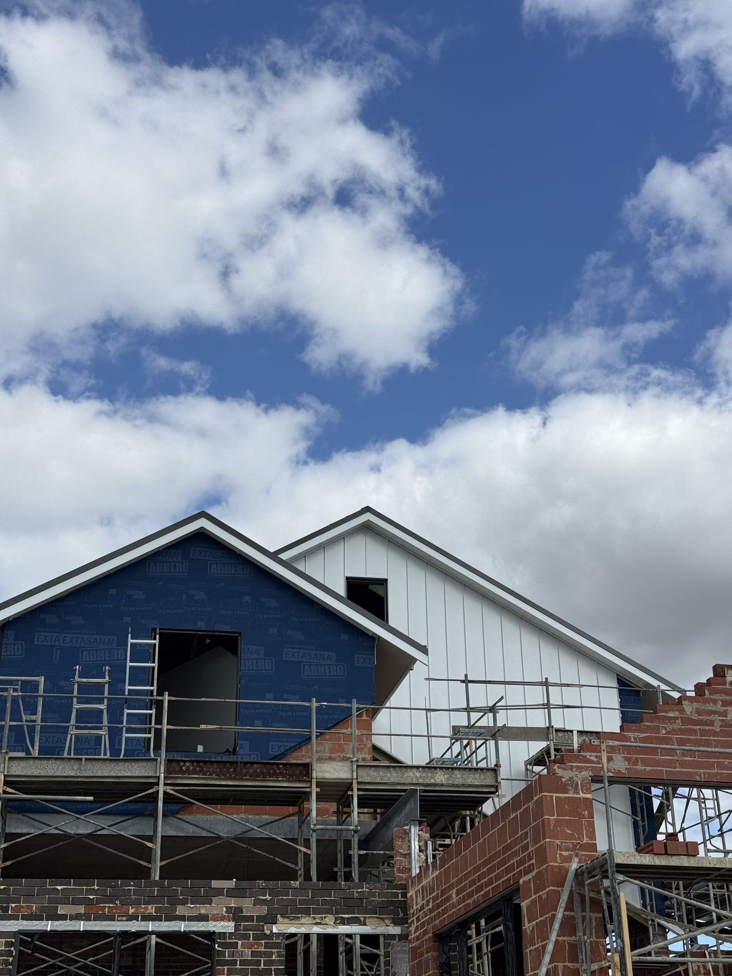 Blue wrap beside new Dover White standing seam cladding on a home in Ascot, Perth