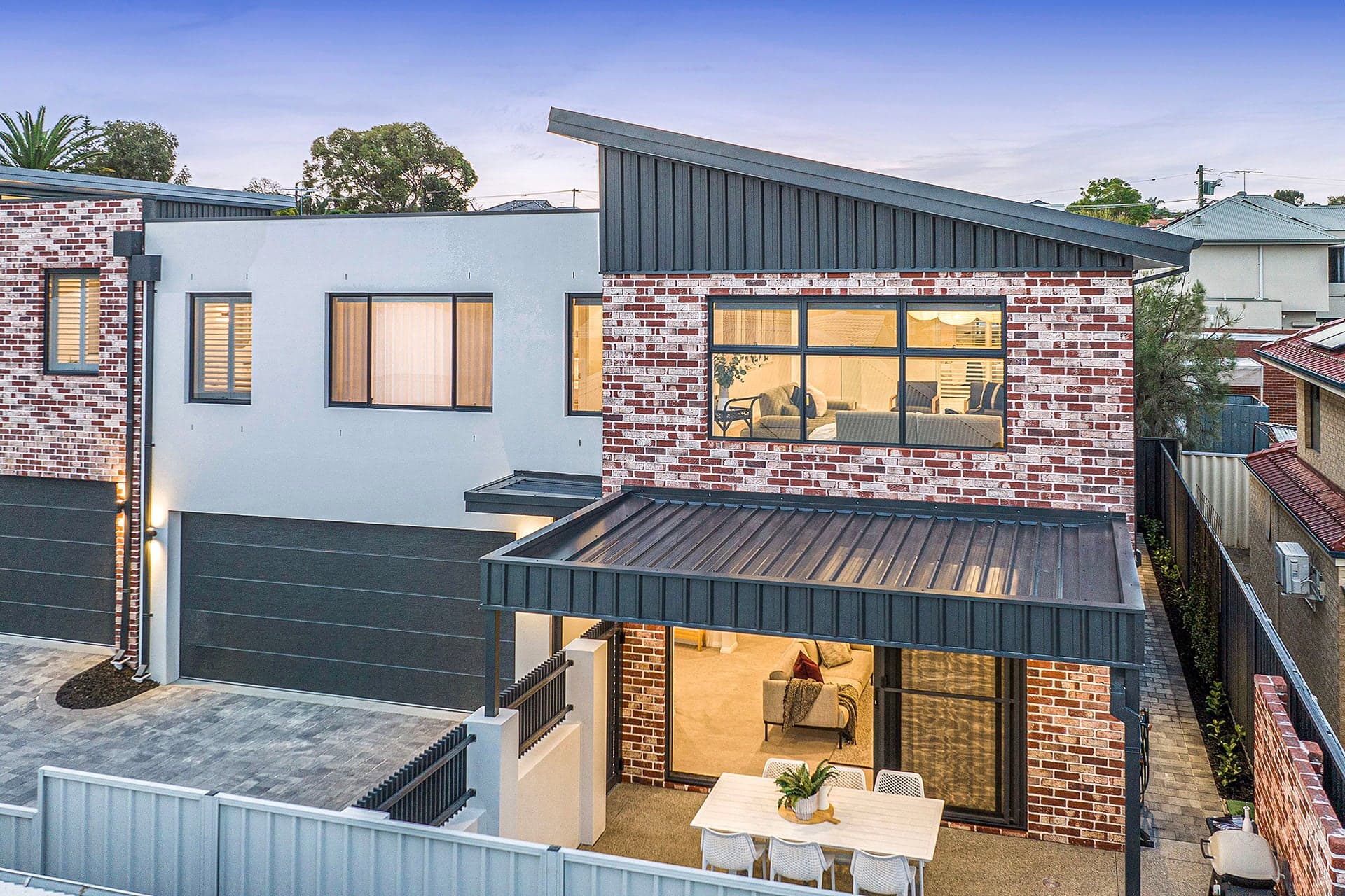 Metal skillion roof on a new brick townhouse at dusk in Yokine, Perth